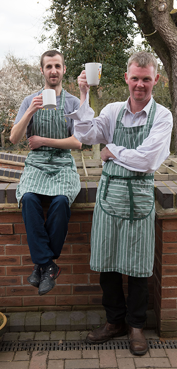 Two people at Growing Lives enjoying a break from cooking with a cup of tea